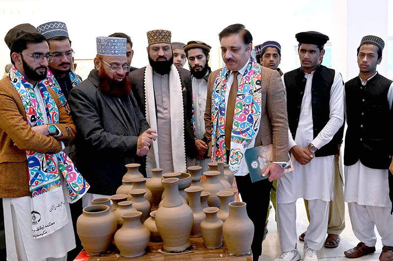 Syed Tauqeer Haider Kazmi, Executive Director of Al-Hammar, appreciates the production of handmade pottery as the organizer briefs him during the Sufism Exhibition at Al-Hammar Hall