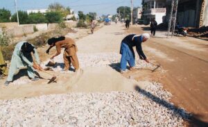 Laborers hard at work constructing a road, paving the way for progress.