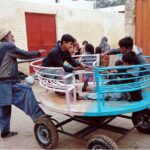 Children enjoying swing on roadside