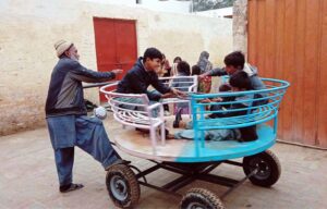 Children enjoying swing on roadside