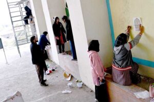 Students are busy painting vibrant artwork to enhance the beauty of the wall on the Zero Point Bridge in the Federal Capital