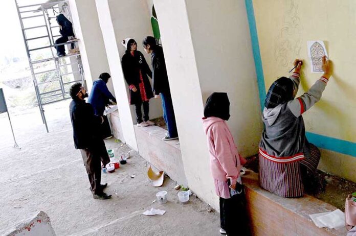 Students are busy painting vibrant artwork to enhance the beauty of the wall on the Zero Point Bridge in the Federal Capital
