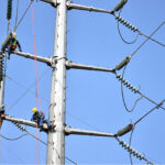WAPDA staffers busy in installing new electricity cables on the electric pole at Ferozpur Road