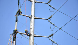 WAPDA staffers busy in installing new electricity cables on the electric pole at Ferozpur Road