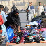 A woman selecting old warm clothes from a roadside vendor