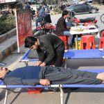 A person donates blood during a blood donation camp organized by Pakistan Sweet Home at Six Road