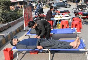 A person donates blood during a blood donation camp organized by Pakistan Sweet Home at Six Road