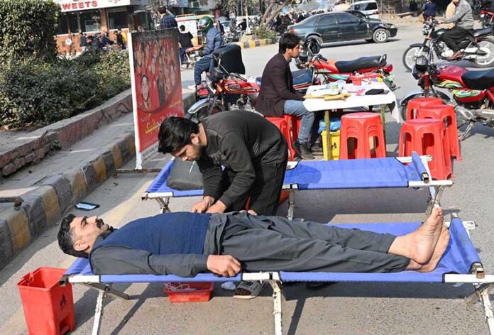 A person donates blood during a blood donation camp organized by Pakistan Sweet Home at Six Road