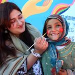 Woman making a painting on a child face during the 2nd Day of PDA Food & Culture family Festival with the support of UNICEF at Regi Model Town Park