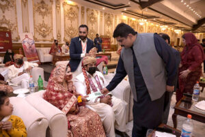 Pakistan Muslim League (N) MPA Taimur Khan Baloch is distributing ATM cards to newly married couples on the occasion of mass marriages under the "Dhi Rani Program" by Chief Minister Punjab at local hotel