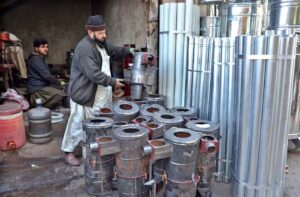 A vendor displaying traditional stove at his shop.