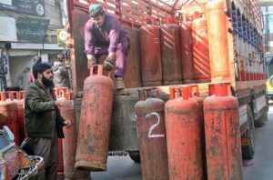 Labourers busy in unloading LPG cylinder from delivery truck at Bahawal Sher Road.