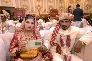 Pakistan Muslim League (N) MPA Taimur Khan Baloch is distributing ATM cards to newly married couples on the occasion of mass marriages under the "Dhi Rani Program" by Chief Minister Punjab at local hotel