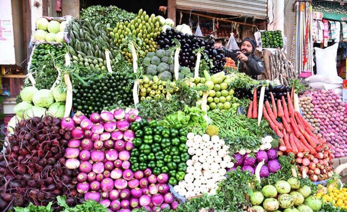 A vendor displaying the fresh vegetables to attract the customers at Lahori Mohalla A vendor displaying the fresh vegetables to attract the customers at Lahori Mohalla
