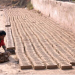 A laborer making raw bricks at a local kiln