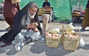 An aged disabled man sells eggs for livelihood at Meezan Chowk.