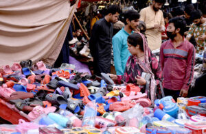 A woman selects shoes for herself and her children at an affordable stall in Nolakha Linda Bazaar.