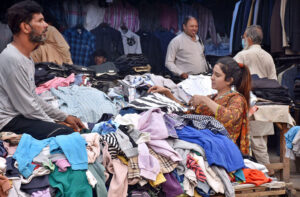 A woman selects shoes for herself and her children at an affordable stall in Nolakha Linda Bazaar.
