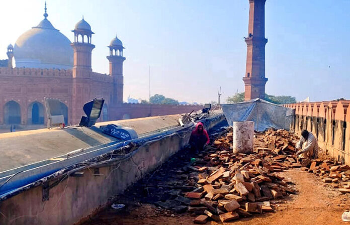Laborers busy restoration work at Badshahi Masjid