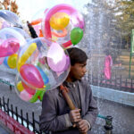 A young vendor selling balloons at Jinnah Bagh