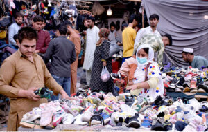 A woman selects shoes for herself and her children at an affordable stall in Nolakha Linda Bazaar.