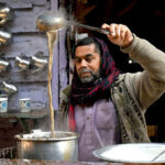 A tea stall vendor prepares fresh tea to a customer at his setup in a local market in the provincial capital