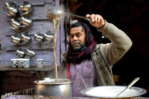 A tea stall vendor prepares fresh tea to a customer at his setup in a local market in the provincial capital