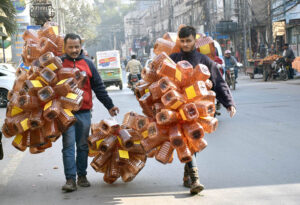 Vendors selling empty plastic bottles while shuttling on the road at Gangaram chowk.