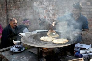 A tea stall vendor prepares fresh tea to a customer at his setup in a local market in the provincial capital