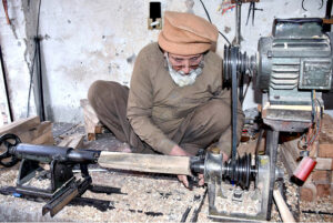 Laborers busy in making parts of traditional bed (Charpai) at their workplace in the Ichara Furniture market