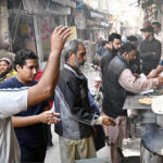 People purchasing traditional breakfast (Halwa Puri) at Garhi Shahu during holiday in the City