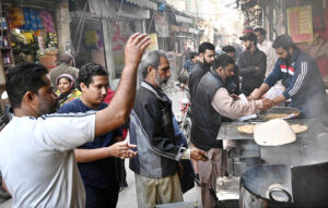 People purchasing traditional breakfast (Halwa Puri) at Garhi Shahu during holiday in the City