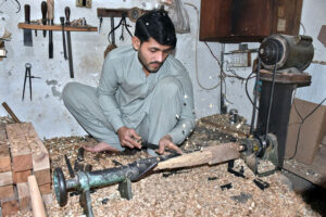 A craftsman meticulously making farm of the furniture used in wedding dowries at Bati Chowk furniture market.