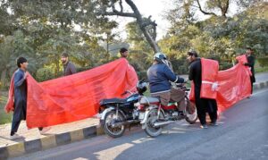 Vendors displaying and selling plastic sheet (tarpal) to attract customers at roadside near Ferozepur Road.