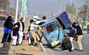 Students helping the auto rickshaw driver to fix the out of order tire on Walton Road.
