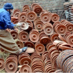 A roadside vendor displays pottery for sale near the Mughalpura Stop
