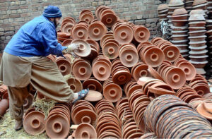 A roadside vendor displays pottery for sale near the Mughalpura Stop