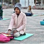 Children from slum area getting education by a volunteer teacher at an open area in F-6 while the world observes International Day of Education
