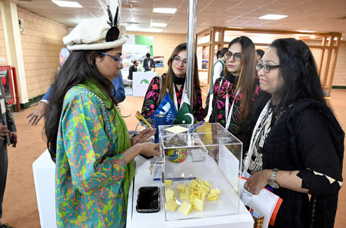 Women Visitor taking interest at Hotels & Resorts Pavilion stall during the Pakistan Travel Mart (PTM) 2025 at Expo Centre