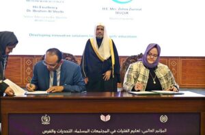 Secretary General of the Muslim World League, Sheikh Dr. Mohammed bin Abdulkarim al-Issa, witnesses Signing of International Partnership Agreements between Senior Advisor the Muslim World League Dr. Ibrahim Al-Shaibi with Director General SESRIC Mrs. Zehra Zumrut Selcuk during Closing ceremony of the International Conference Girls Education at Jinnah convention Centre