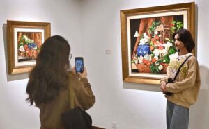 A visitor capturing picture with the on displayed artwork at exhibition “A Spring Reverie - Petals & Porcelain” by talented still life artist, Irfan Cheema in Tanzara Gallery