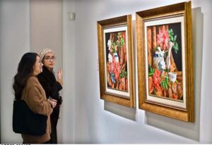 A visitor capturing picture with the on displayed artwork at exhibition “A Spring Reverie - Petals & Porcelain” by talented still life artist, Irfan Cheema in Tanzara Gallery