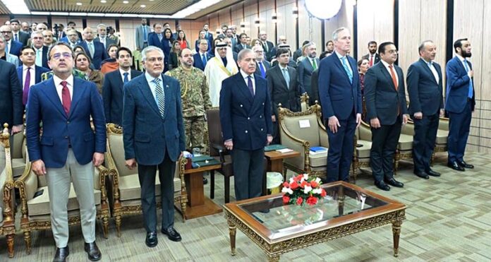Prime Minister Muhammad Shehbaz Sharif and other guests standing in respect of the national anthem of Pakistan during the launching ceremony of World Bank's Country Partnership Framework for Pakistan