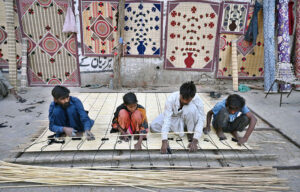 Workers busy in preparing traditional curtains (chicks) at court road.