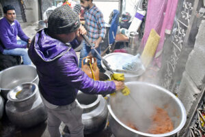 A confectioner prepares the popular winter souvenir dish carrot halwa for sale at Golmandi Foot Street.