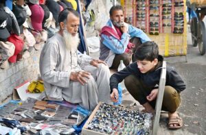 A boy selecting ring from road side vendor.