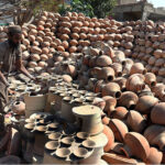 A worker arranging clay-made stuff for drying purpose at his work place at Kumharpara