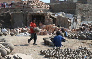 A worker arranging clay-made stuff for drying purpose at his work place at Kumharpara