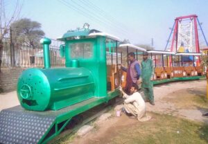 Workers busy paint mini train in Chenab Park.