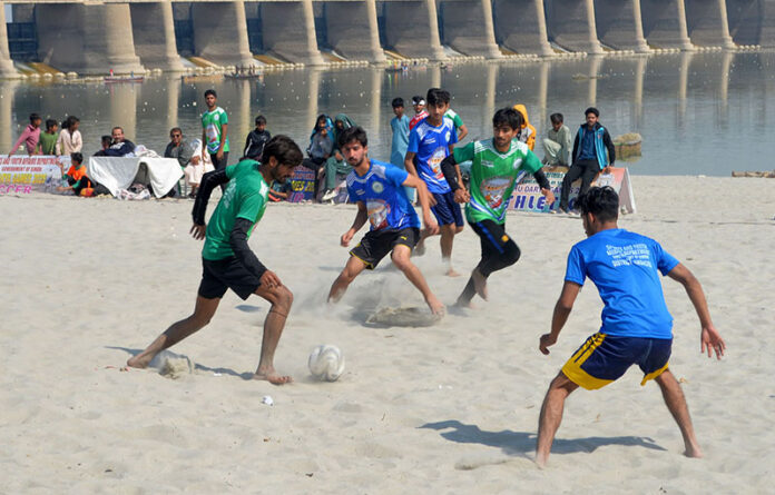 Football players in action during Sindh darya games 2025 organized by sports and youth affair department at bank of Indus River